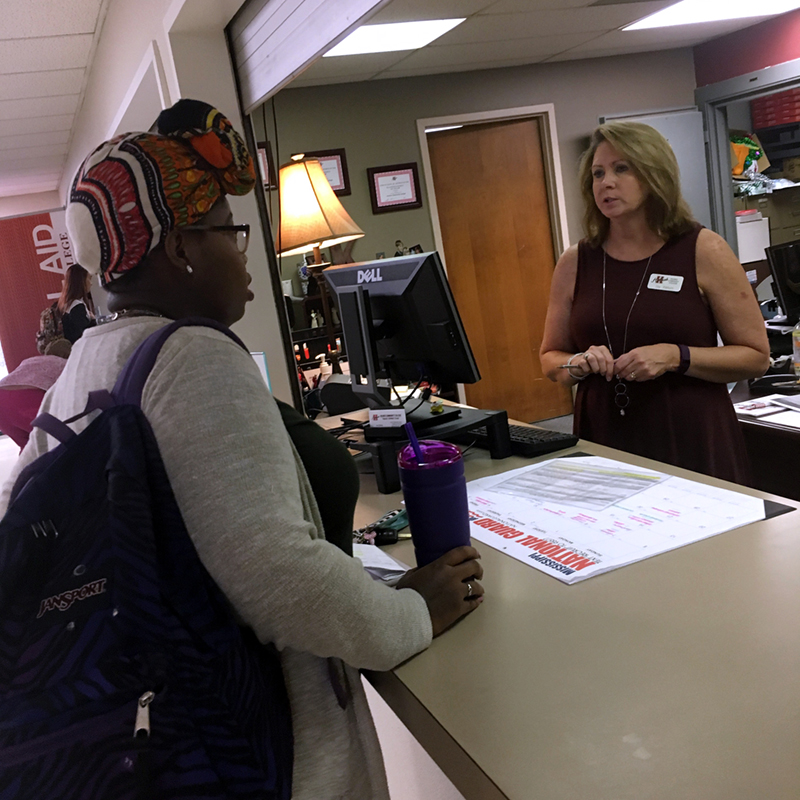 Business Office manager Joy Kellum assists a student with first-day tasks.